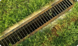Yard drainage grate surrounded by grass in Kirkwood
