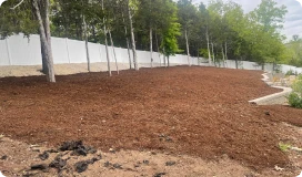Freshly mulched yard area with trees and white fence in Chesterfield