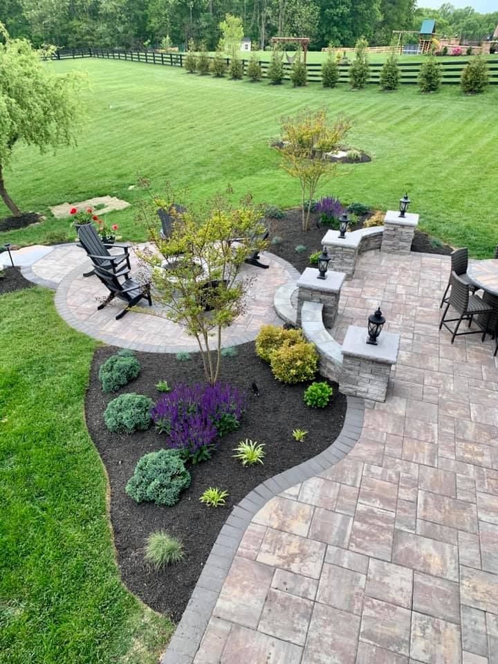 Stone patio with seating walls, mulch beds, and colorful plants in Chesterfield